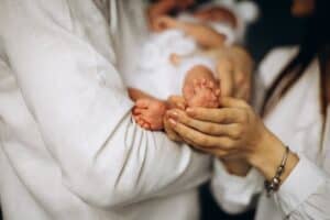 kobieta trzyma w ramionach niemowlę